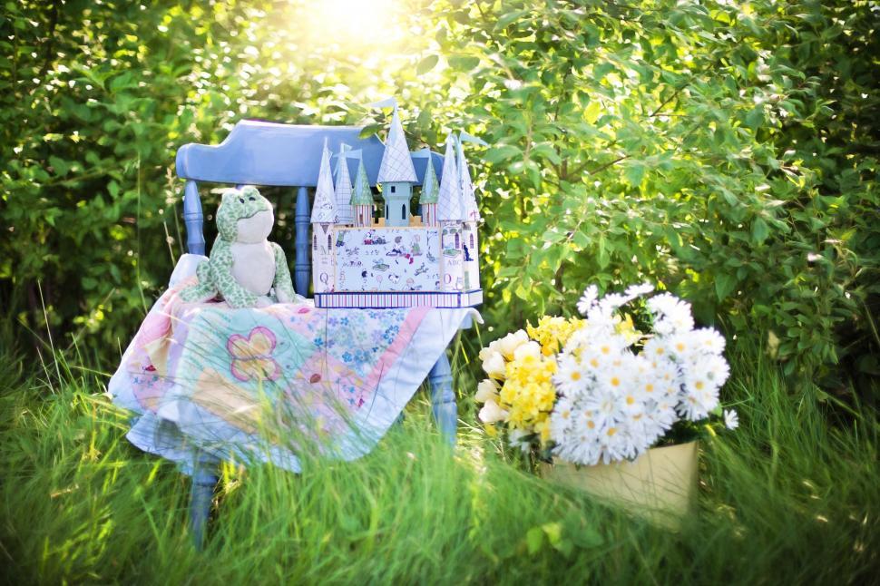 Free Image of Child\'s Castle Toy With Basket of Daisy Flowers in the garden 